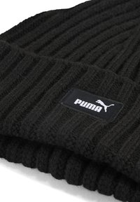 Beanie nero lavorato a maglia con texture a coste e risvolto. Presenta un'etichetta nera rettangolare con il logo bianco "PUMA" e un'immagine di un puma in salto.