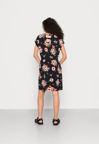 Vestido floral preto com mangas curtas, apresentando um recorte nas costas e uma cintura ajustada. O tecido tem uma textura suave com padrões florais coloridos.