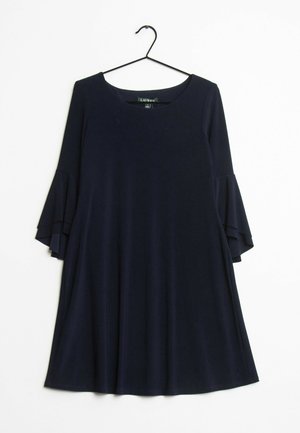 Ciemnogranatowa sukienka z rozkloszowanymi, trzyczęściowymi falbanami na rękawach, zawieszona na czarnym wieszaku na białym tle.