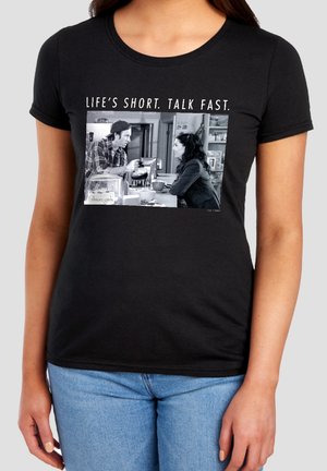 Black t-shirt with a black-and-white scene of a man and woman talking at a diner counter, captioned "LIFE'S SHORT. TALK FAST."
