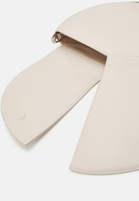 Borsa in pelle beige dalla forma arrotondata, con chiusura a zip e una texture liscia, che presenta una tasca interna con dettagli di cucitura minimi.