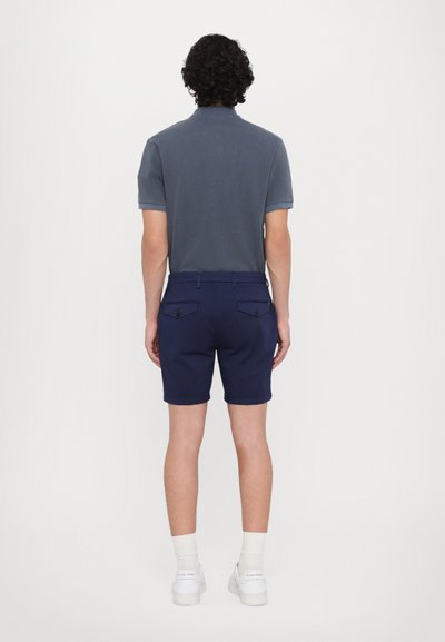 Shorts marine cu o croială adaptată, confecționați dintr-un material rezistent. Dispune de două buzunare la spate și un exterior plat, asortat cu o cămașă gri cu guler.
