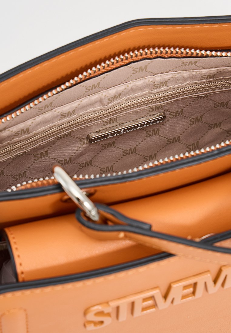 Interno di una borsa in pelle con finitura arancione, tasca con zip, texture liscia e fodera beige con un motivo logo ripetuto.