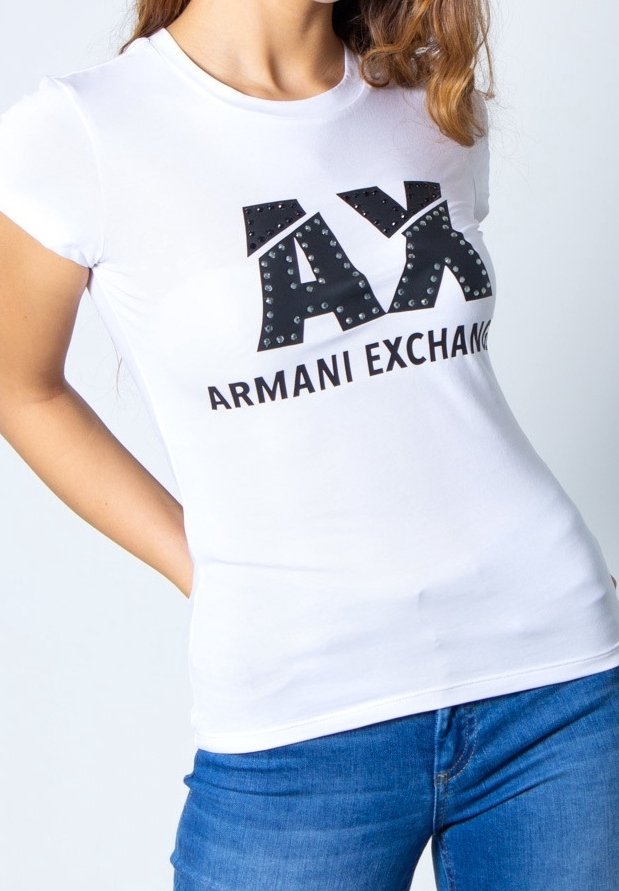 Bílý přiléhavý tričko s velkým černým logem "AX" s akcenty z rhinestone a textem "ARMANI EXCHANGE", v kombinaci s modrými džíny.