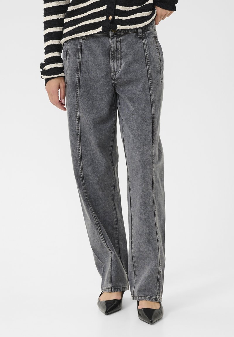 Aukštos juosmens pilkos džinsinės kelnės su laisvu siluetu, turinčios pirmosios siūlės ir blukimo efektą. Derinamos su smailėjančiomis juodomis aukštakulnėmis.