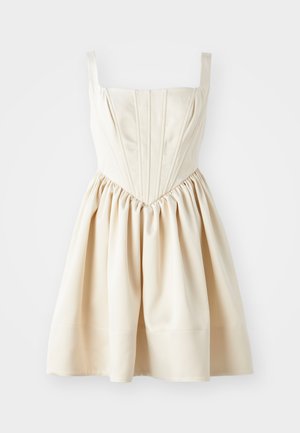Cream-colored dress featuring a square neckline, fitted bodice with pleats, and a gathered skirt, made from smooth fabric. Adjustable straps.