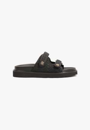 Must must sandaal, millel on tekstuuriga rihm, millel on teemantmuster, kahekordsed reguleeritavad Velcro kinnitused ja paks pehmendusega talla.