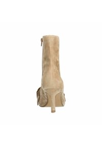 Beige suède hoge hak enkellaars met een ritssluiting, met een gladde textuur en een slank ontwerp, verfraaid met een strikdetail aan de zijkant.