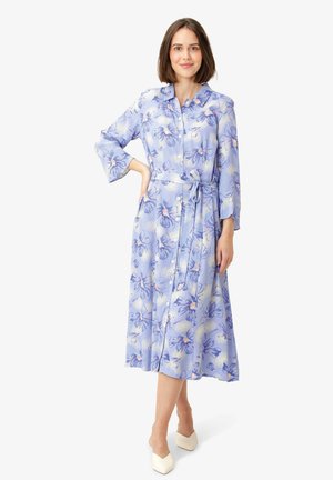 Light blue floral dress featuring button-up front, long sleeves, belted waist, and a flowy silhouette; fabric has a soft texture and subtle sheen.