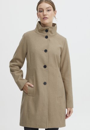 Manteau en laine beige avec un col haut, quatre boutons noirs, poches latérales et manches longues, présentant une coupe droite et une texture douce.