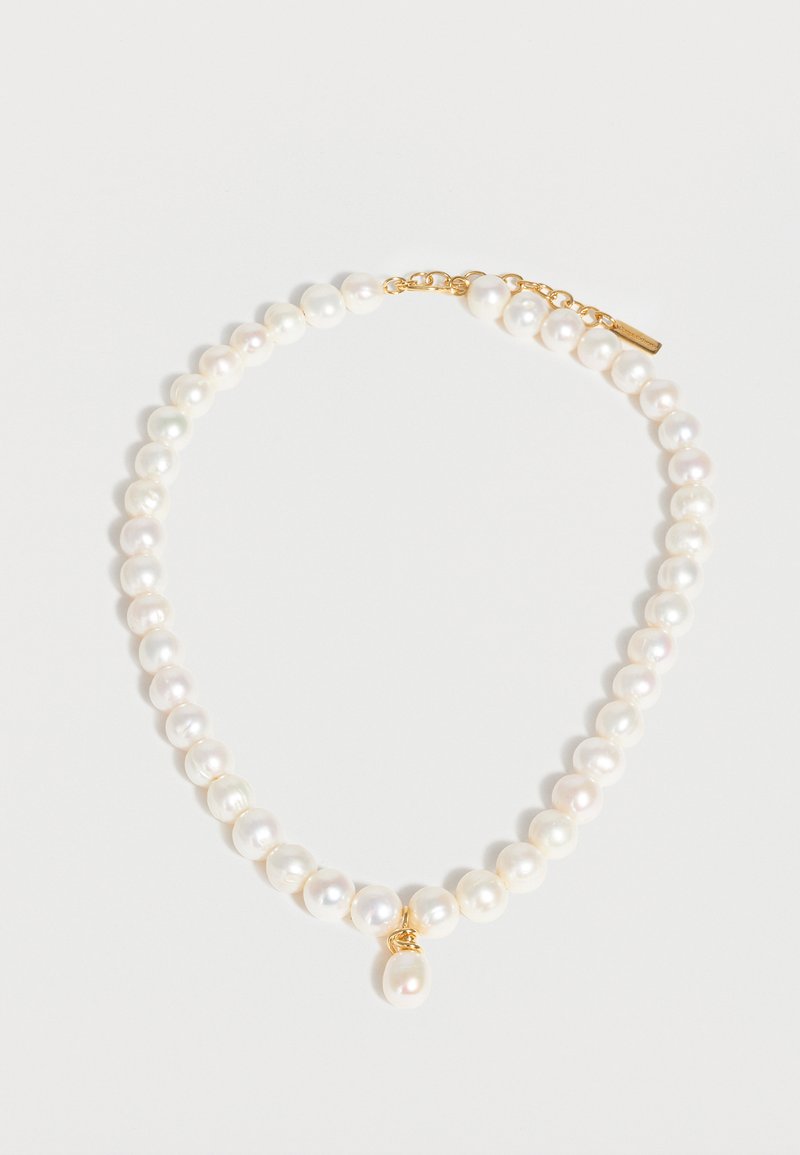 Μουσαμάς από λευκές στρογγυλές πέρλες με ένα μενταγιόν από μία μόνη πέρλα, στερεωμένο με μια κοντή χρυσή αλυσίδα με κούμπωμα σε λευκό φόντο.