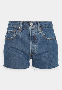 Denimshorts i mörkblått med fransad nederkant, femficksdesign och koppardetaljer. Tillverkade av textilerad bomull.