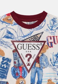 Βαμβακερό T-shirt με στρογγυλή λαιμόκοψη σε μαρόν αποχρώσεις, με πολύχρωμο γραφικό τύπωμα από αρκουδάκια και ναυτικά στοιχεία, καθώς και ένα τριγωνικό εμβληματικό σήμα.