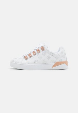 Baskets basses blanches avec des logos gris subtils, des œillets de lacets pêche et un accent pêche sur le talon, présentées sur un fond uni.