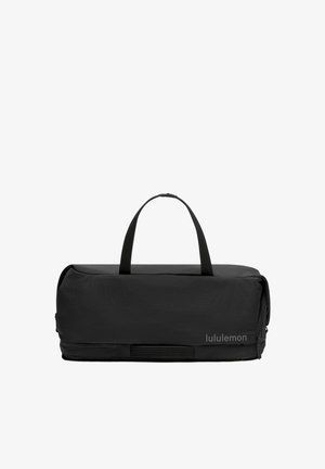 Sac de sport rectangulaire noir avec deux poignées et un compartiment zippé, avec le nom de la marque "lululemon" en bas à droite.