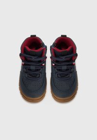 Zapatillas altas de color azul marino con un exterior texturizado, forro interior rojo, suela de goma marrón y cordones duraderos a juego. Presenta agujeros de ventilación.