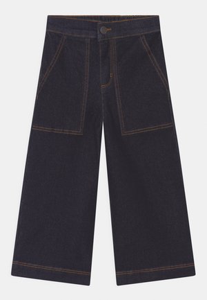 Pantalons en denim foncé à jambe large avec une taille haute, dotés de grandes poches avant et de coutures dorées contrastantes.