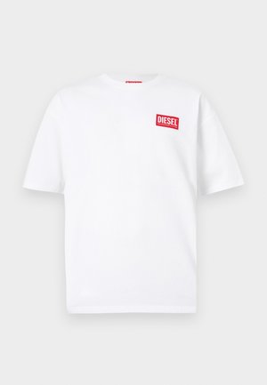 White cotton t-shirt with short sleeves, featuring a red rectangular label with "DIESEL" text on the left chest area.