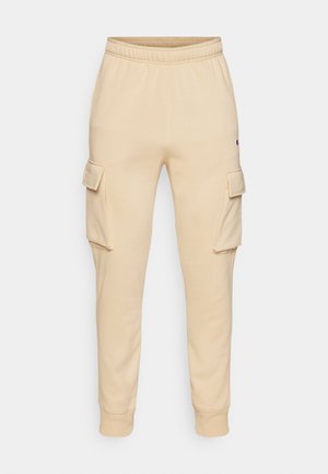 Beige Baumwoll-Sweatpants mit einem Kordelzugbund, gerippten Bündchen und zwei Cargo-Taschen an den Seiten. Glatte Textur und lässiges Design.