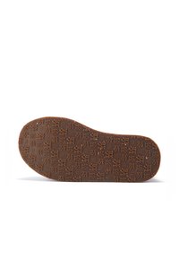 Suela de goma marrón con un intrincado patrón en relieve que presenta varios símbolos, forma redondeada y textura suave, diseñada para calzado.