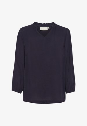 Jūras zila blūze ar V veida kakla izgriezumu un frillētu apkakli, ar garām piedurknēm ar nedaudz savilkta aproce un taisnu apakšmalu. Gluda auduma tekstūra.