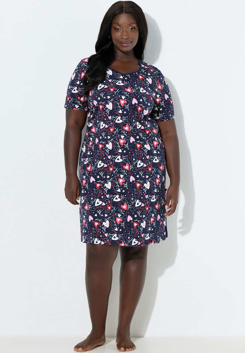 Nachthemd mit kurzen Ärmeln aus weichem Stoff, mit dunkelblauem Grund und buntem Herzmuster. Schlichte, bequeme Passform.
