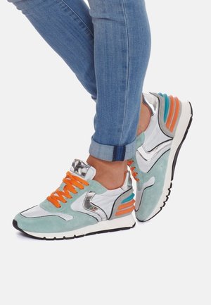 Sneaker con una toma in suede verde menta, dettagli in argento, lacci arancioni e una suola bianca spessa con dettagli laterali colorati.