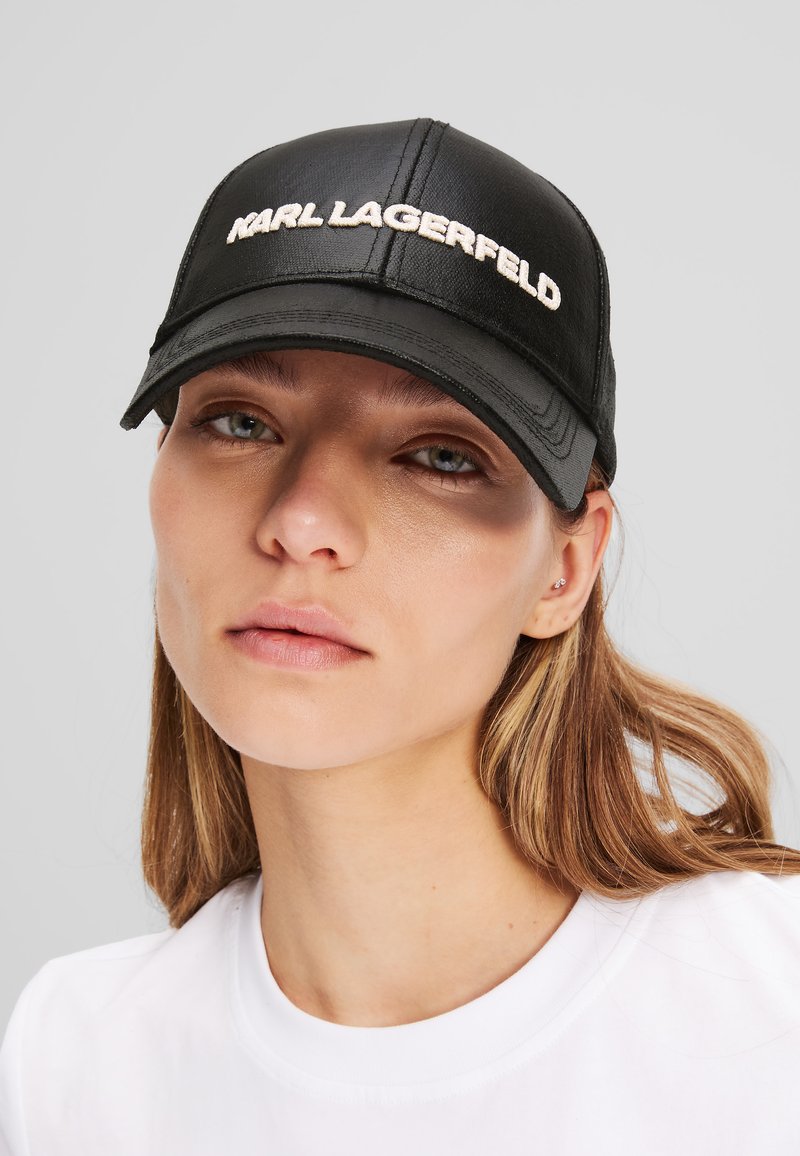 Čierna čiapka z umelého materiálu s vyšitým logom "KARL LAGERFELD" v krémovej farbe, s klasickým zakriveným okrajom a štruktúrovaným dizajnom.