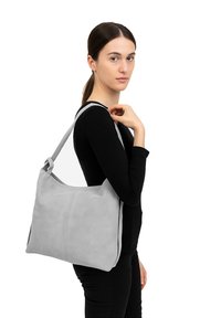 Borsa a spalla grigia, con una superficie morbida, dotata di una sola tracolla. Caratterizzata da un design semplice e una forma arrotondata. Leggera e spaziosa, ideale per l'uso quotidiano.