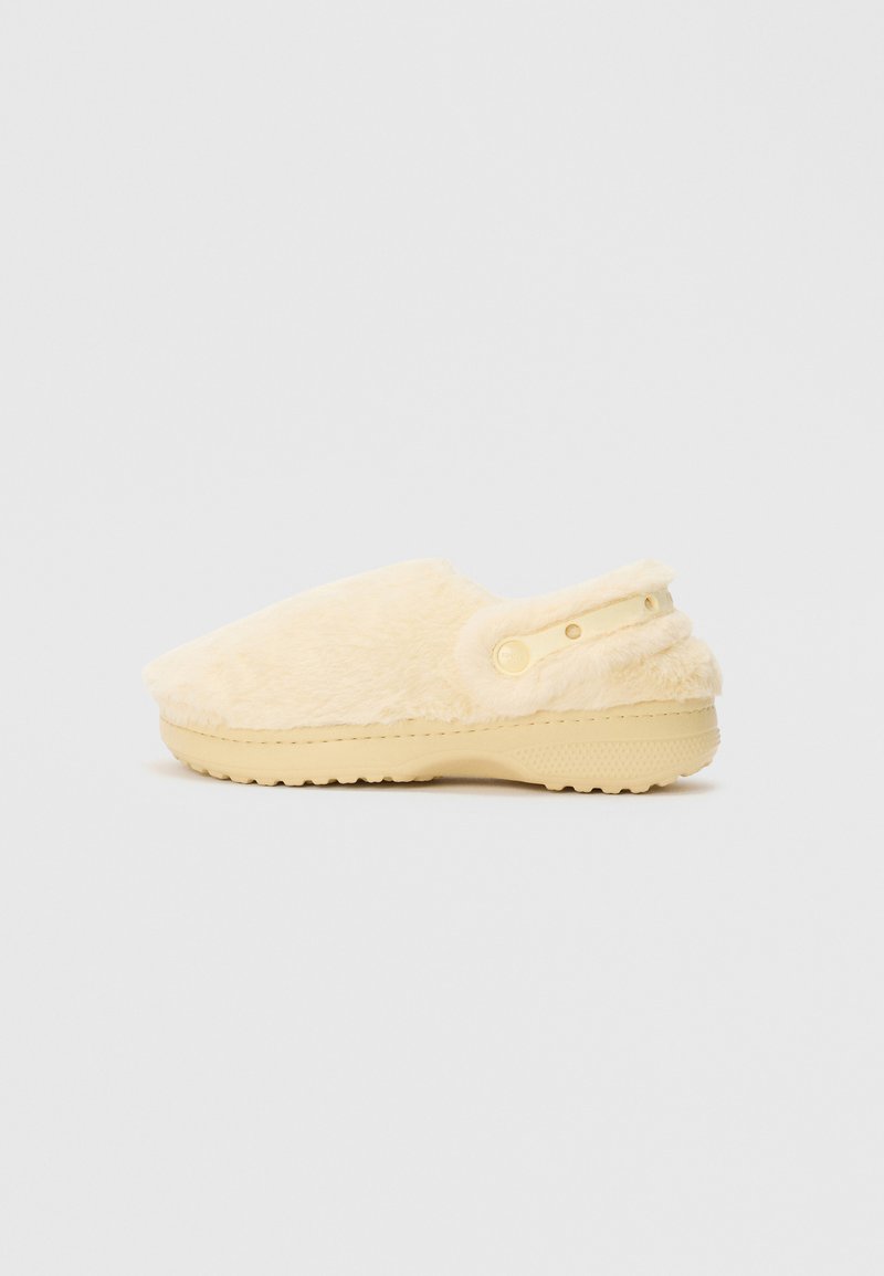 Clog felpudo em tom de creme, com correia traseira ajustável e sola texturizada, adequado para uso em ambiente interno ou externo.