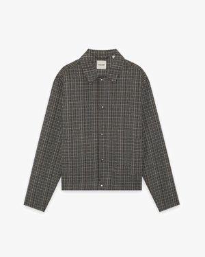 Veste-chemise pour homme à manches longues, en tissu gris à carreaux, avec boutons sur le devant et col. Coupe ajustée avec un motif à carreaux subtil.