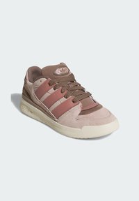 Svijetlo ružičaste sportske tenisice od suedea s smeškim kožnim prugama i pertlama, okrugli vrh, teksturirana potplat i kružni logo na jeziku.