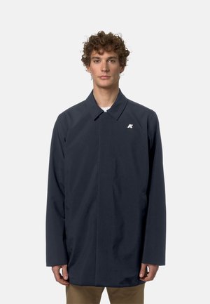 Cappotto impermeabile blu navy con colletto classico, maniche lunghe e chiusura frontale. Presenta un piccolo logo sul lato sinistro del petto. Tessuto liscio.
