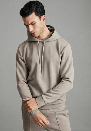 Hoodie bej deschis, fabricat dintr-un material moale, având o glugă cu șnur, mâneci lungi, manșete cu țesătură rib și o croială lejeră.