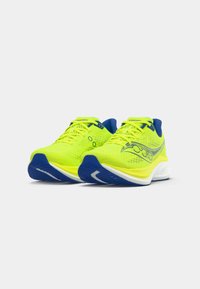 Neon yellow athletic shoes with blue accents, featuring a textured mesh upper, rounded toe, and a cushioned white sole.