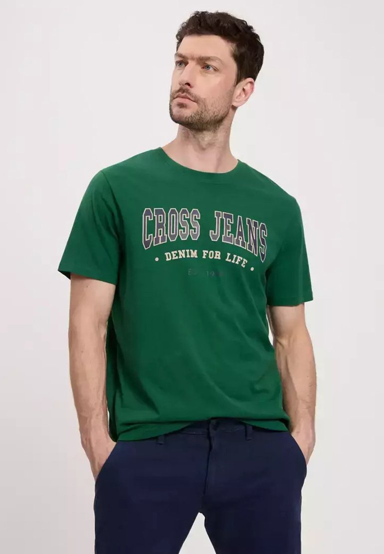 Zielona bawełniana koszulka z nadrukiem "CROSS JEANS DENIM FOR LIFE" w kontrastowych kolorach. Posiada okrągły dekolt i krótkie rękawy.