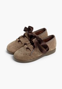 Zapatos de ante marrón con detalles perforados, puntera redondeada y cintas anchas de satén atadas en la parte frontal. Suela flexible de goma marrón.