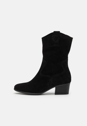 Botte mi-mollet en daim noir de style western avec un talon bloc bas et des coutures décoratives sur le côté et la tige supérieure.