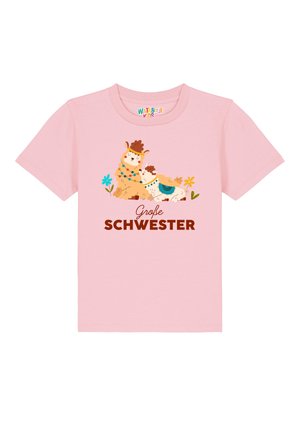 Rosa T-Shirt mit kurzen Ärmeln, das cartoonhafte Lamas und Blumen zeigt. "Große Schwester" in fettem braunem Text unter dem Design gedruckt.