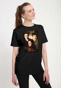 Černé bavlněné tričko s potiskem tří postav z "Twilight ságy" na tmavém texturovaném pozadí.