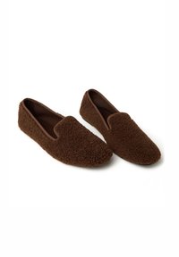 Pantuflas de felpa marrones con un exterior suave y texturizado y un forro interior liso. Presentan una punta redondeada y un diseño sin hebillas, fácil de poner.