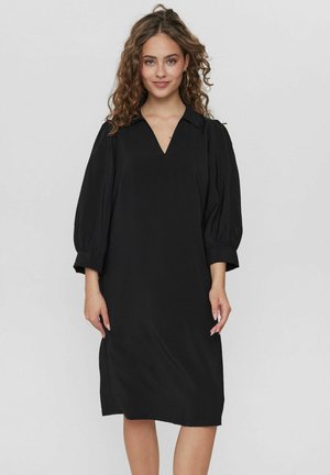 Zwarte jurk tot de knieën met een V-hals, geplooide mouwen en een losse pasvorm. Gemaakt van een gladde stof met een minimalistisch design en zonder patronen.