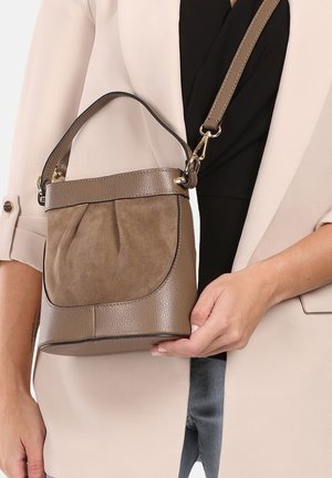 Braune Handtasche mit einer strukturierten Wildlederfront und glatten Lederakzenten. Verfügt über einen kurzen Griff und einen abnehmbaren Schultergurt. Klappendetail vorhanden.