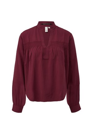 Burgundy long-sleeve blouse with a mandarin collar, smocked detailing across the chest, and elasticized cuffs. Soft, flowing fabric.
