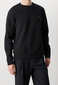 Černá mikina z bavlněné směsi s kulatým výstřihem, žebrovanými manžetami a lemem a malým logem na hrudi.