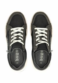 Sneaker grigio scuro con lacci bianchi, upper in rete testurizzata e dettagli lisci. Presenta una zip laterale e un logo sulla soletta per un tocco di stile.