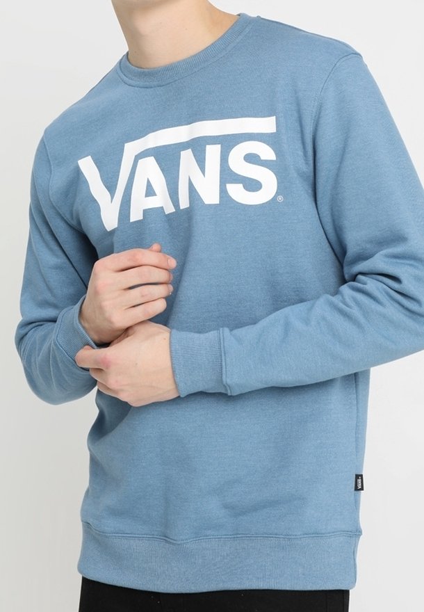 Modrá mikina z měkké látky s velkým bílým logem "VANS" přes hruď. Kulatý výstřih a žebrované manžety a lem.