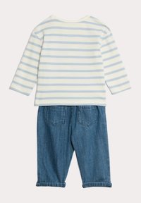 Randig långärmad skjorta i ljusblått och vitt, kombinerad med blå denimbyxor med uppvikta fållar och två bakfickor.