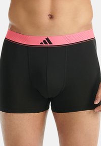 Czarne bokserki z różową elastyczną talią, na której znajduje się teksturowany pasek i czarne logo. Zaprojektowane z dopasowanym kształtem i miękkim materiałem.