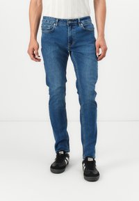 Blå denimjeans med et slim fit design, som har fem lommer, en knapp- og glidelås-lukking, samt subtile falming detaljer for tekstur.